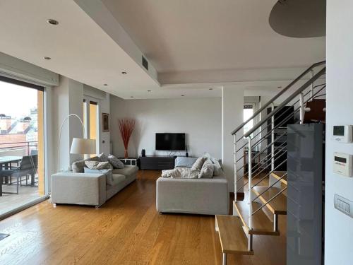 uma sala de estar com dois sofás e uma escada em Penthouse Suite - Skyline view em Busto Arsizio