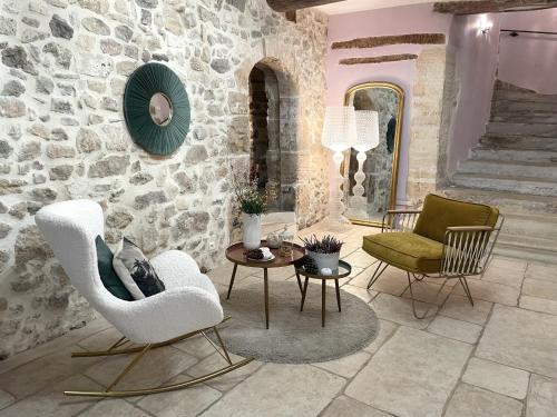 B&B Temps Suspendu Provence في بيرنيه لو فونتينز: غرفة معيشة مع كرسيين وطاولة