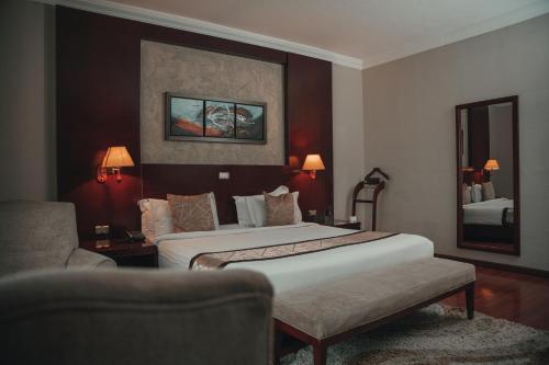 a hotel room with two beds and a chair at Sidra International Hotel in Addis Ababa