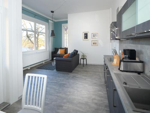 cocina con sofá y mesa en una habitación en Moderne Ferienwohnungen in alter Villa en Georgenthal