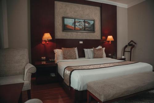 a hotel room with a bed and a chair at Sidra International Hotel in Addis Ababa