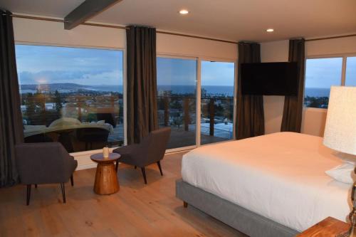 een slaapkamer met een bed en een groot raam bij The Mermaid House in San Diego