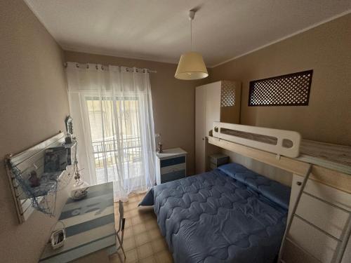 een kleine slaapkamer met een blauw bed en een raam bij Sea Sunsets - Apartments - Falerna Lido - Gizzeria Lido in Gizzeria