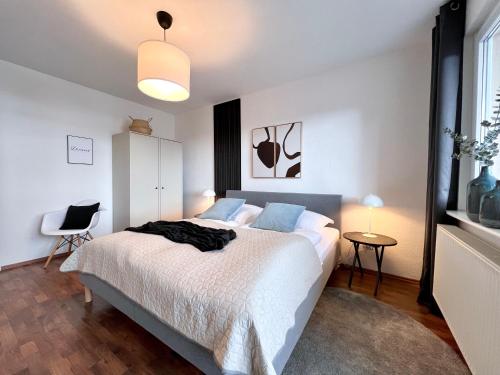 a bedroom with a bed with white sheets and blue pillows at SABE APARTMENT: BALCONY + FREE PARKING + NETFLIX in Wuppertal