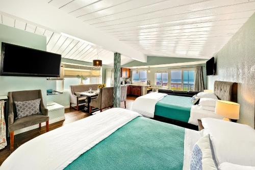 a hotel room with two beds and a flat screen tv at OB Pier 2 in San Diego