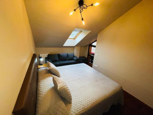 a small bedroom with a bed and a couch at APARTAMENTOS RioMonte 5 - DeLuxe con Jacuzzi in Boltaña