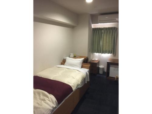 een hotelkamer met een bed en een raam bij Toss Station Hotel Matsuzaka - Vacation STAY 52279v in Tosu