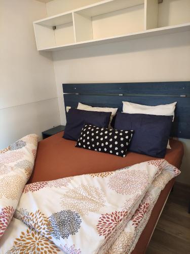 Un dormitorio con una cama con almohadas. en Mipro Mobilhome 5 en Lido di Spina