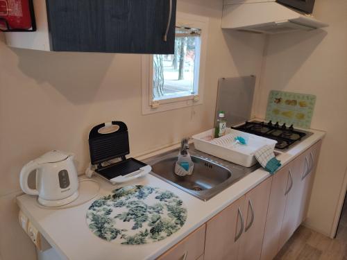 a kitchen with a sink and a counter top at Mipro Mobilhome 5 in Lido di Spina