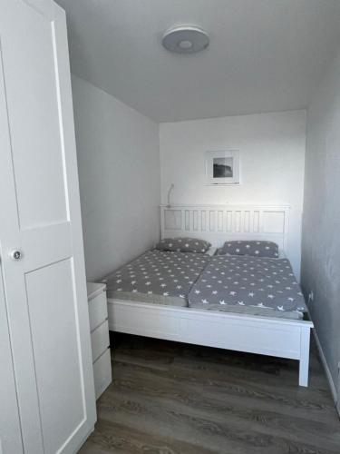 Un dormitorio con una cama blanca en una habitación. en Lee, en Fehmarn