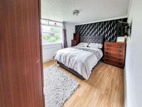 a bedroom with a bed and a dresser and a window at Beach Tonic in Humberston