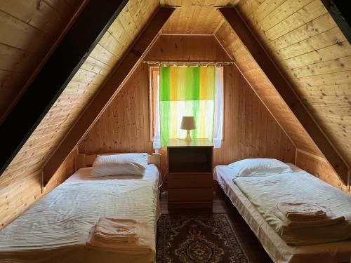 2 camas en una habitación con ventana en Sportovně rekreační areál Ráj Srbsko en Kněžmost