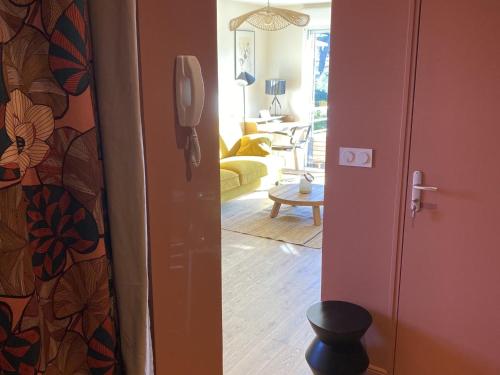 un couloir avec une porte s'ouvrant sur un salon dans l'établissement Charmant T2 moderne près du port de La Teste avec parking, balcon et Wi-Fi - FR-1-474-240, à La Teste-de-Buch