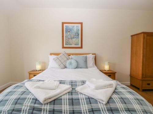 ein Schlafzimmer mit einem großen Bett mit Handtüchern darauf in der Unterkunft Rectory Farm View in Queen Camel