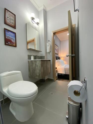 a bathroom with a toilet and a sink and a bed at Cal Bed & Breakfast in Bogotá