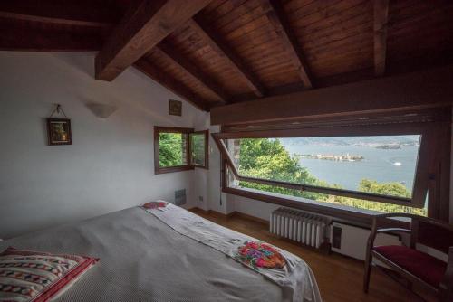 a bedroom with a bed and a large window at Villa Gia in Stresa