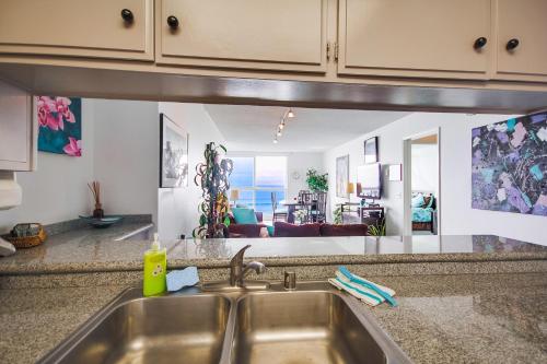 a kitchen sink with a view of a living room at Beachview Condo in San Diego