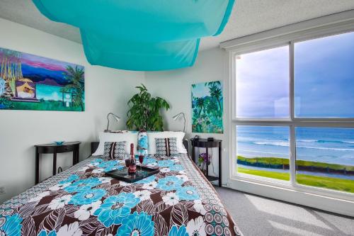 a bedroom with a bed with a view of the ocean at Beachview Condo in San Diego