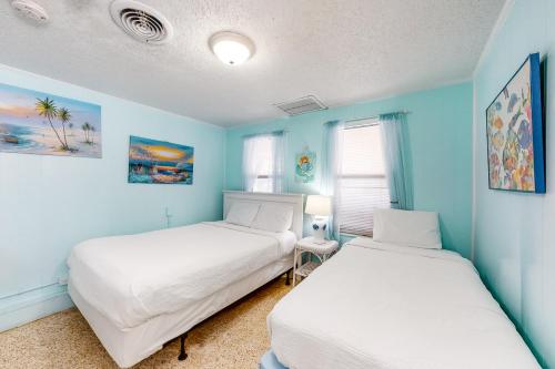 2 camas en una habitación con paredes azules en O'Grady's Little Villa en Panama City Beach