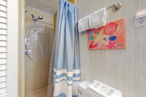 baño con ducha con cortina azul en O'Grady's Little Villa en Panama City Beach