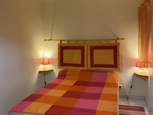 a bedroom with a colorful bed with two lamps at Charmant gîte rénové avec terrasse privative, jardin et parking - Animaux acceptés - FR-1-489-10 in Neuvy