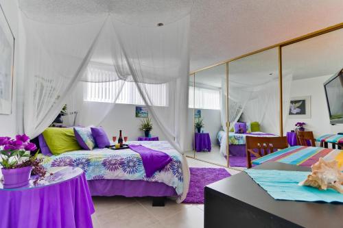 a bedroom with purple beds and a large mirror at Pool View Condo in San Diego