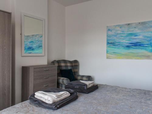 1 dormitorio con 1 cama, 1 silla y 1 pintura en Mere House en Morecambe