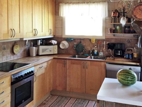 a kitchen with wooden cabinets and a sink at Four-Bedroom Holiday home in Dalarö in Dalarö