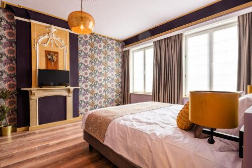 WatervlietにあるBoutique hotel Siesのベッドとテレビ付きのホテルルーム