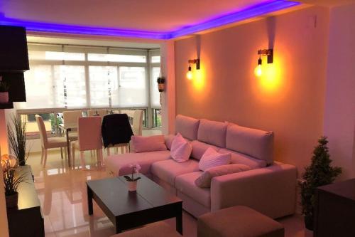 a living room with a pink couch and a table at Apartamento amplio y céntrico in Fuengirola