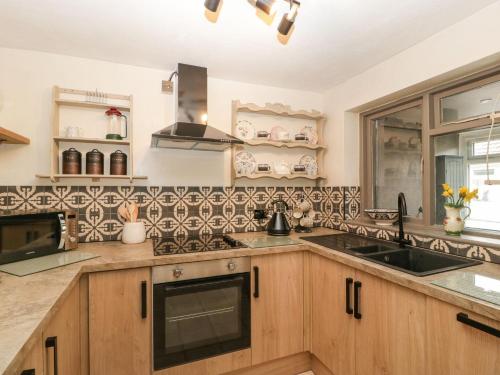 a kitchen with wooden cabinets and a sink at Beau Hideaway in Dorchester