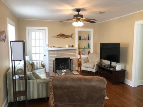 a living room with a couch and a television at Calypso Pensacola in East Hill Neighborhood ! in Pensacola