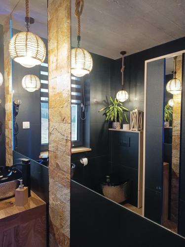 a bathroom with black walls and pendant lights at Lux Houses DOMEK z widokiem na Tatry z prywatnym jacuzzi in Gliczarów