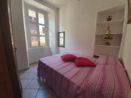 ein Schlafzimmer mit einem Bett mit roten Kissen darauf in der Unterkunft Rosa&Mario Lake House in Verbania