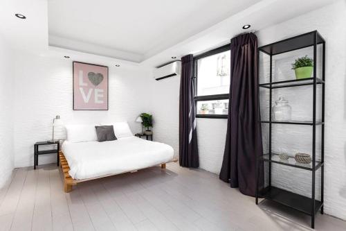 - une chambre avec un lit blanc et une fenêtre dans l'établissement Heart of Tel Aviv, Duplex Apartment 12, à Tel Aviv