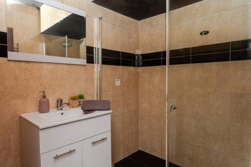 La salle de bains est pourvue d'un lavabo et d'une douche. dans l'établissement Heart of Tel Aviv, Duplex Apartment 12, à Tel Aviv