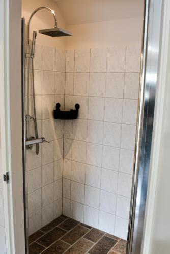 a bathroom with a shower with a glass door at Gastenverblijf De Weldadigheid in Eesveen