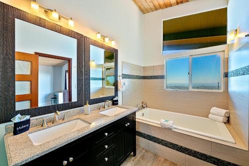 a bathroom with two sinks and a tub and two mirrors at Pacifica View in San Diego