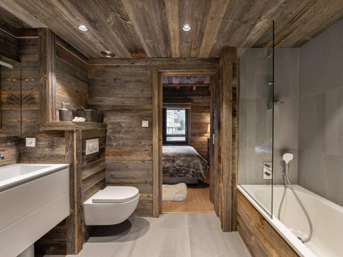 une salle de bain avec toilettes et lavabo et un lit dans l'établissement Duplex moderne proche pistes avec terrasse et parking privatif - FR-1-566-42, à Les Allues