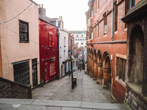 an alley with buildings and people walking down the street at 12 Bed Clifton Townhouse in Bristol