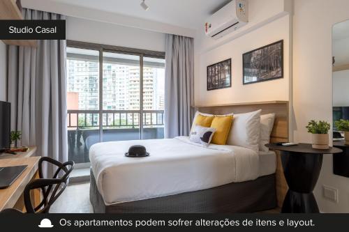 a hotel room with a bed and a desk and a window at Smart Charlie Parque Augusta Mackenzie in Sao Paulo