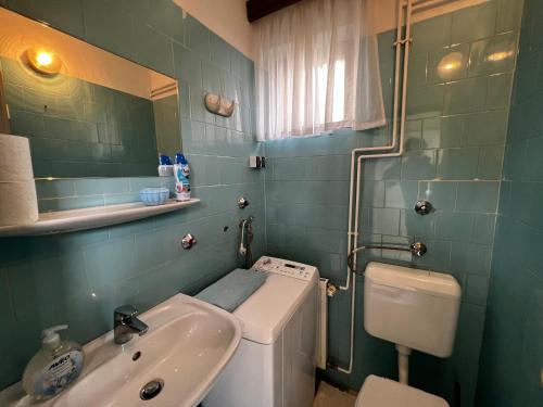 a bathroom with a sink and a toilet and a mirror at Noémi nyaralóház in Bük