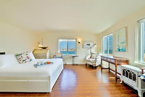 a bedroom with a large white bed and a desk at On The Beach Clubhouse in San Diego