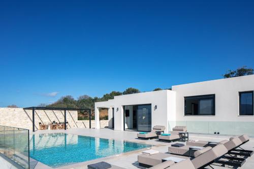 eine Villa mit einem Pool und Liegestühlen in der Unterkunft Villa Kafkales Maleme - Heated Pool in Maleme