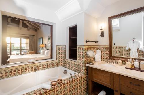 a bathroom with a tub and a sink and a mirror at Rancho Santana in El Limón