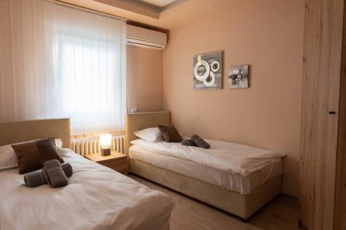 een slaapkamer met 2 bedden en een raam bij Key Apartments in Novi Sad