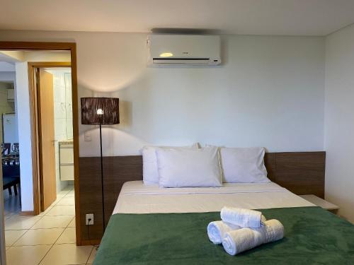 um quarto com uma cama com duas toalhas em Bela Hospedagem - #Atlântico Sul 408 - Flat com vista para o mar em João Pessoa