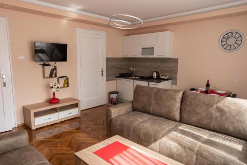 een woonkamer met een bank en een keuken bij Key Apartments in Novi Sad