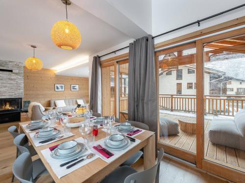 une salle à manger avec une table et des chaises et un salon dans l'établissement Appartement neuf, 8 pers, proche télésiège et pistes, Les Belleville - FR-1-570-26, à Levassaix