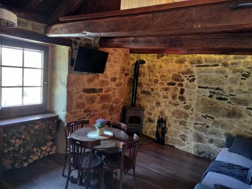 comedor con mesa y estufa de leña en El Cuarto en Suarbol